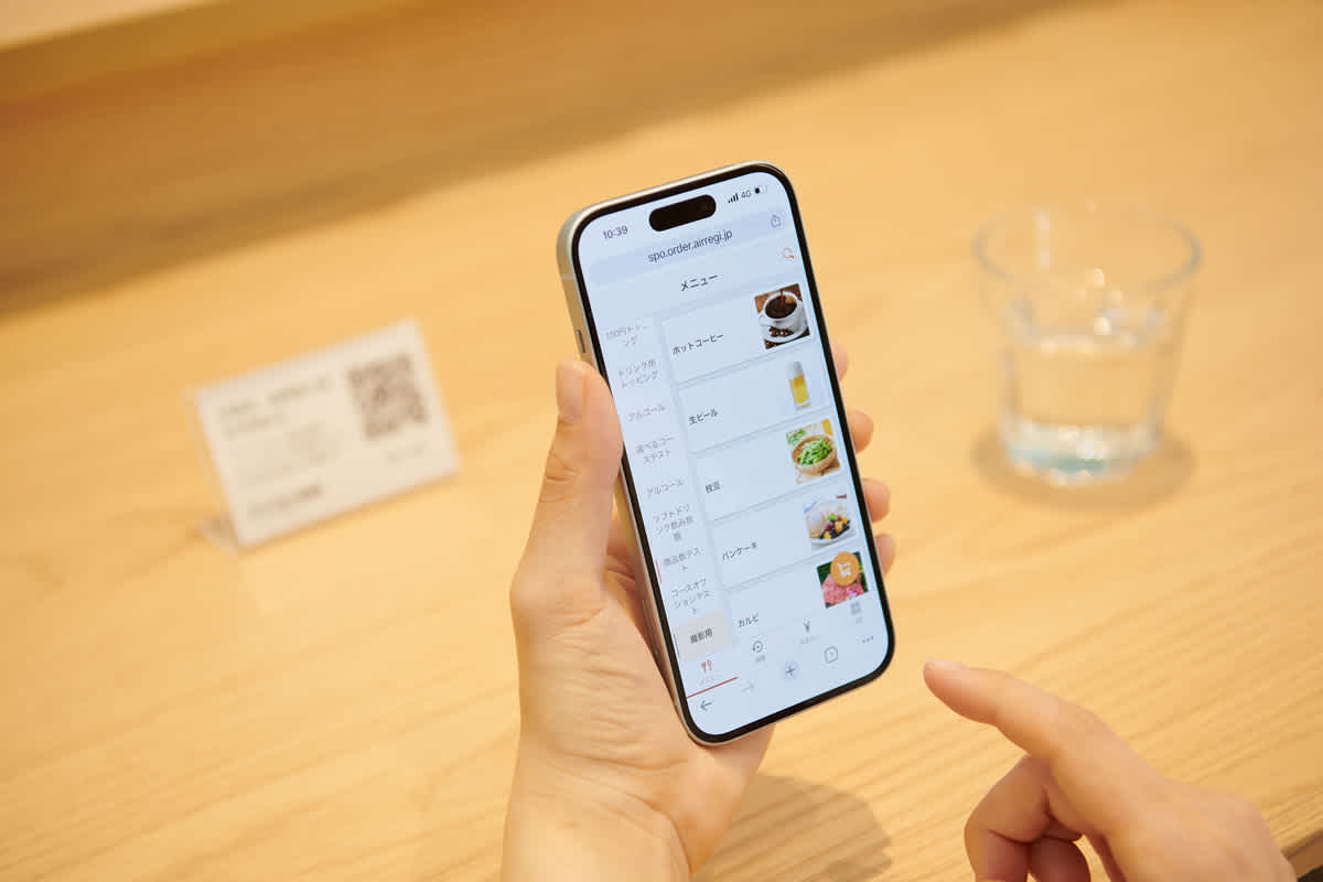 An image of a user operating "AirREGI Order" on a mobile phone