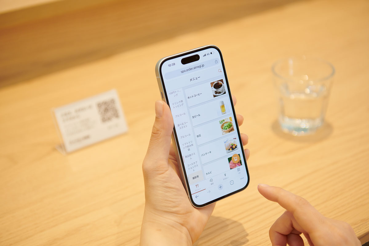 ユーザーがモバイルフォンで『Airレジ オーダー』を操作しているイメージ